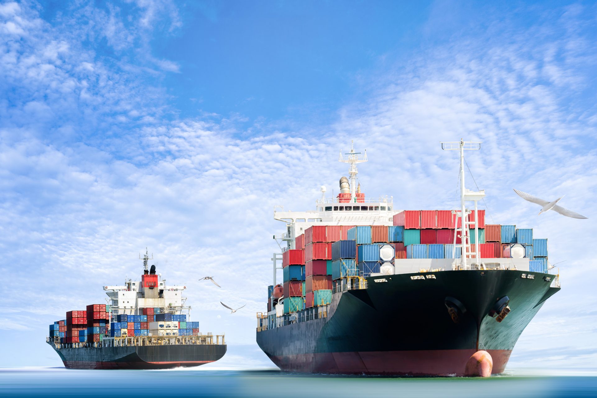 container-cargo-ship-in-the-ocean-with-birds-flying-clear-seas