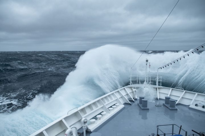 During rough seas, the bow of the expedition cruise ship MS Bremen (Hapag-Lloyd Cruises) collides with large waves, creating a spectacular splash and spray