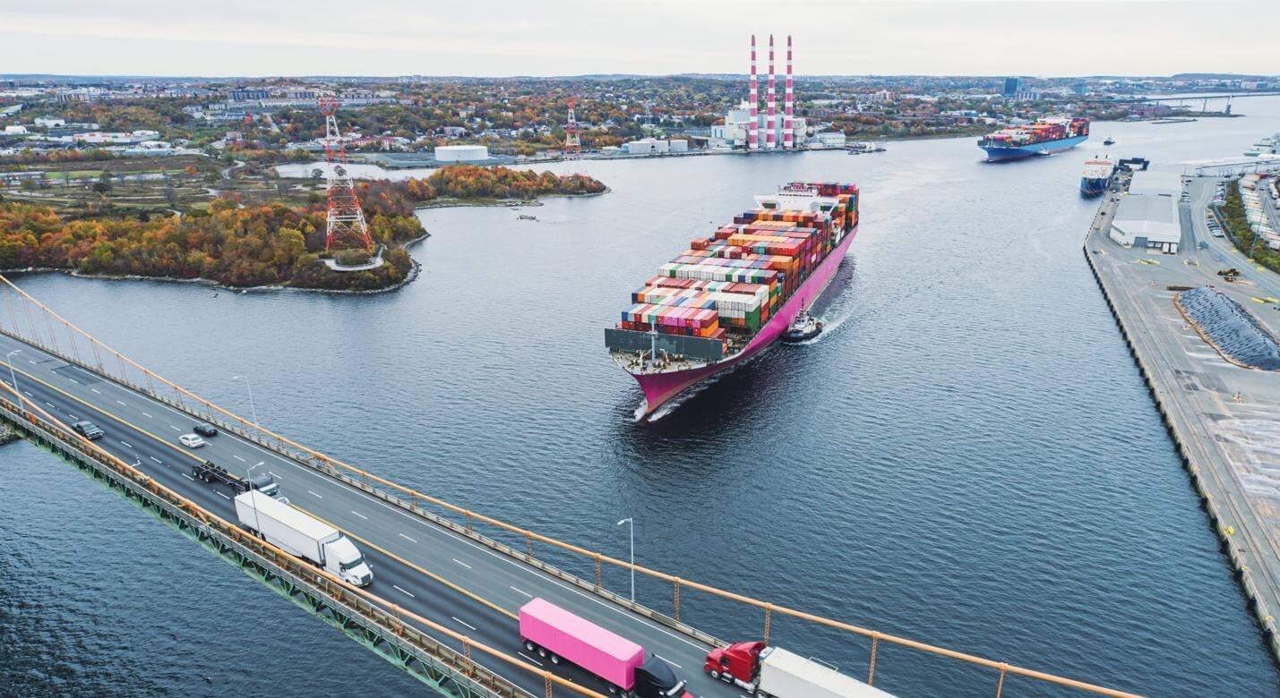 container ship passes under a bridge