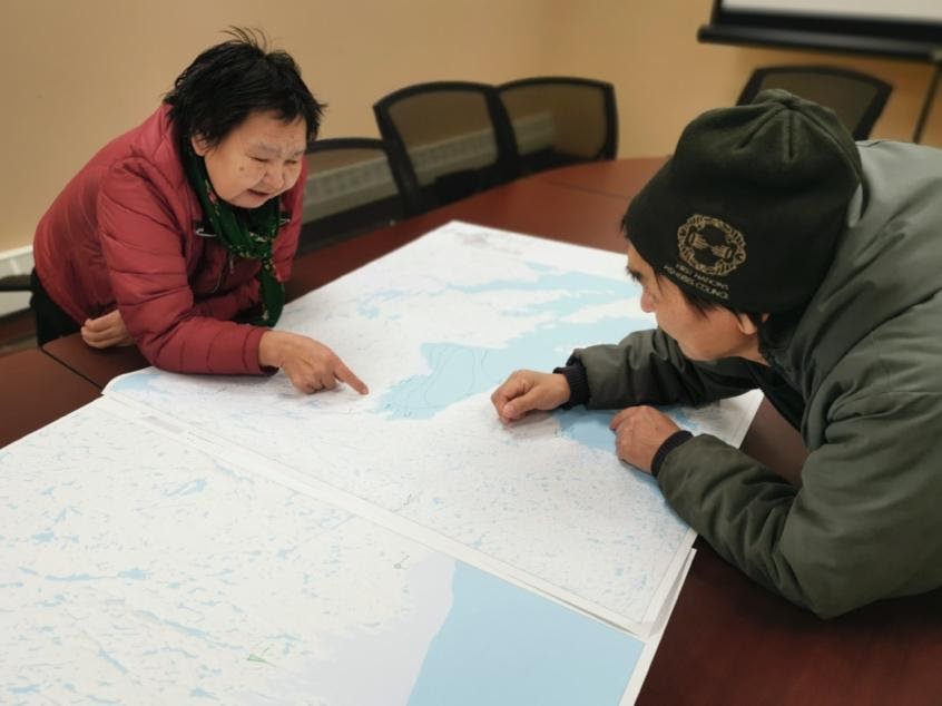 Members of Naujaat, Nunavut study the coastline during one of the community participatory mapping workshops held as part of the CRN initiative.